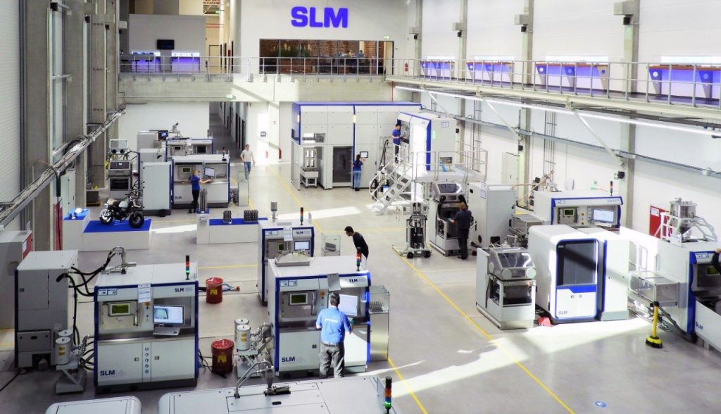 AM factory floor with metal 3D printers, powder handling stations, and other associated systems from SLM Solutions.